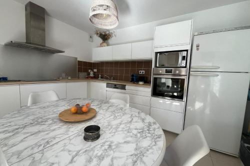 une cuisine avec une table avec un bol de fruits dessus dans l'établissement Nice and cozy apartment in the heart of Leucate, à Leucate