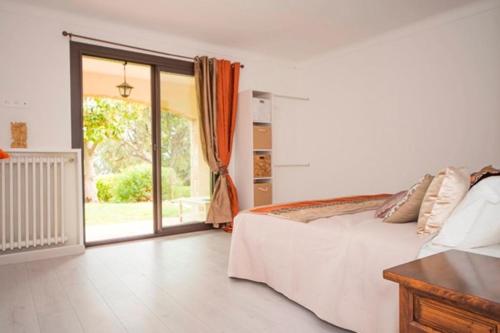 une chambre avec un lit et une porte coulissante en verre dans l'établissement Villa vue mer, à Mandelieu-la-Napoule