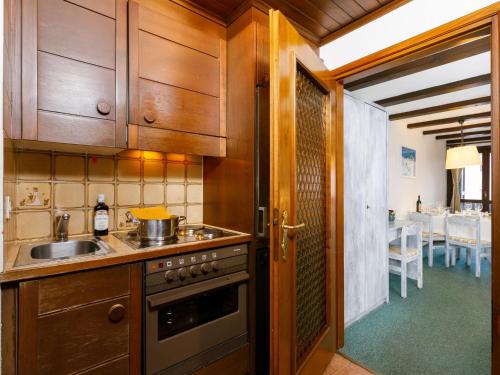 a kitchen with wooden cabinets and a sink and a stove at Apartment Residenza Chesa Margun 13-6 by Interhome in Surlej