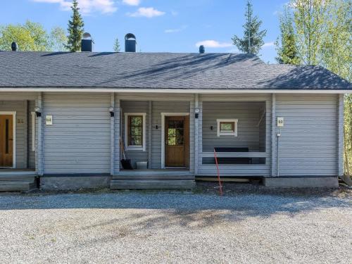 a gray house with a porch and a door at Holiday Home Isonparit b3 by Interhome in Ylläsjärvi