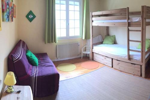 Cette petite chambre comprend des lits superposés et un canapé. dans l'établissement Villla plain pied climatisée spacieuse 6 pers proche des plages - V0303, à Vias