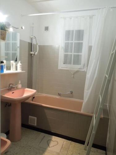 une salle de bain avec une baignoire, un lavabo et une fenêtre dans l'établissement Villla plain pied climatisée spacieuse 6 pers proche des plages - V0303, à Vias