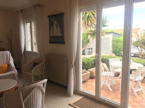 d'un salon avec une porte coulissante en verre et une terrasse. dans l'établissement Villla plain pied climatisée spacieuse 6 pers proche des plages - V0303, à Vias