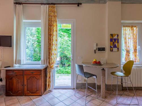 Una cocina con mesa y sillas y una ventana. en Holiday Home Atelier-2 by Interhome, en Invorio Inferiore