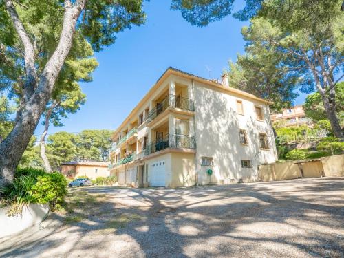 une grande maison avec des arbres devant elle dans l'établissement Apartment Les Goelands by Interhome, à Saint-Cyr-sur-Mer
