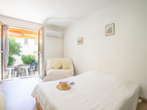une chambre avec un lit, une chaise et une fenêtre dans l'établissement Apartment Le Lido-3 by Interhome, aux Lecques