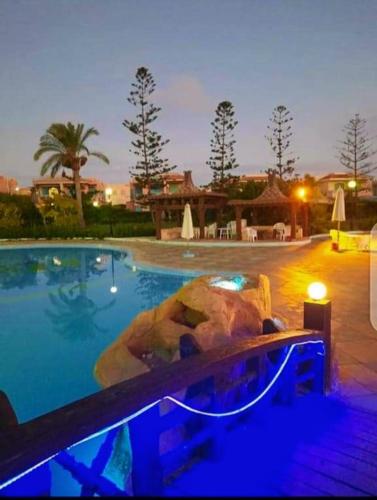 a swimming pool at a resort at night at قرية nice 1 الساحل الشمالي in Dawwār ‘Abd Allāh