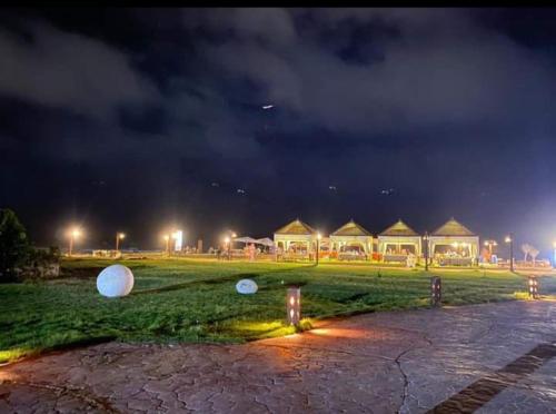 a field with a group of huts at night at قرية nice 1 الساحل الشمالي in Dawwār ‘Abd Allāh