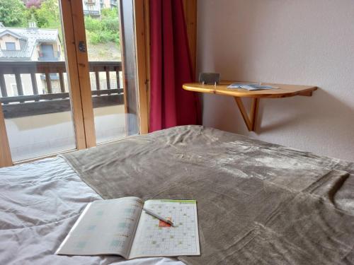 un livre posé sur un lit à côté d'une fenêtre dans l'établissement Apartment Jardins Alpins 2 by Interhome, à Saint-Gervais-les-Bains