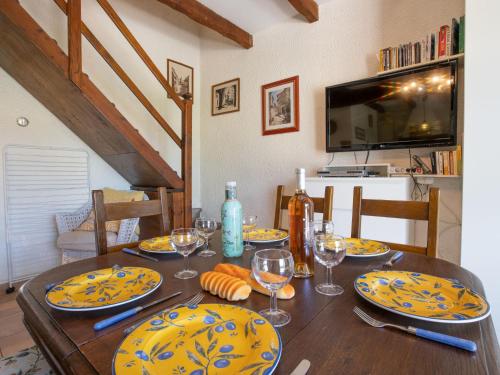 - une table à manger avec des assiettes et des verres à vin dans l'établissement Holiday Home Les Jardins de Sinople by Interhome, à La Madrague