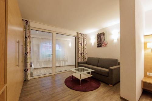 a living room with a couch and a table at Apartmenthaus Goldeck in Ried im Oberinntal