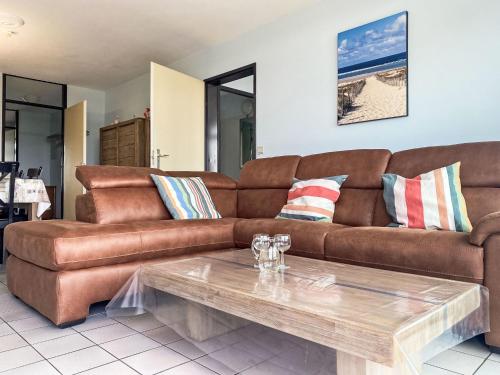 a living room with a brown couch and a coffee table at Apartment Astrid 602 with balcony by Interhome in Bredene