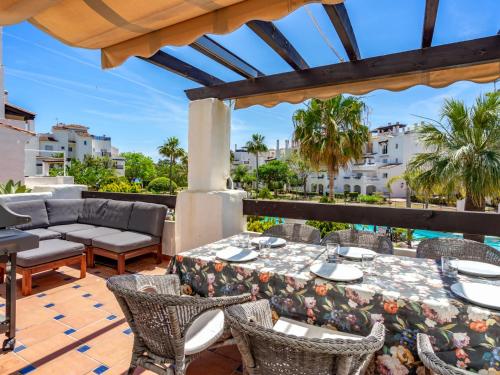 a patio with a table and chairs on a deck at Apartment Las Adelfas by Interhome in Marbella