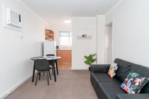 una sala de estar con un sofá y una mesa en Apartment 25 Burswood, en Perth