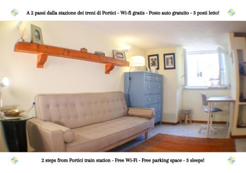a living room with a couch and a shelf on the wall at PORTICI - Casa con Posto Auto Gratuito e Wi-Fi a 2 passi dalla Circumvesuviana e a 10 minuti dal mare in Portici