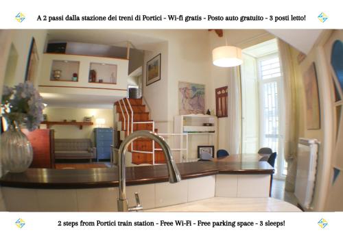 a kitchen with a sink and a living room at PORTICI - Casa con Posto Auto Gratuito e Wi-Fi a 2 passi dalla Circumvesuviana e a 10 minuti dal mare in Portici