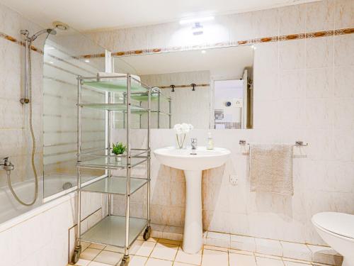 La salle de bains est pourvue d'un lavabo et d'une étagère en verre. dans l'établissement Apartment Le Masséna by Interhome, à Nice