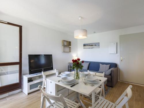 Il comprend un salon doté d'une table blanche et d'une télévision. dans l'établissement Apartment Les Balcons de l'Atlantique-15 by Interhome, à Vaux-sur-Mer