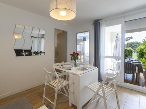 une cuisine avec une table et des chaises et une fenêtre dans l'établissement Apartment Les Balcons de l'Atlantique-15 by Interhome, à Vaux-sur-Mer