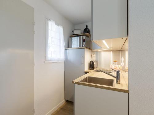 une cuisine avec un évier et un réfrigérateur dans l'établissement Apartment Les Balcons de l'Atlantique-15 by Interhome, à Vaux-sur-Mer