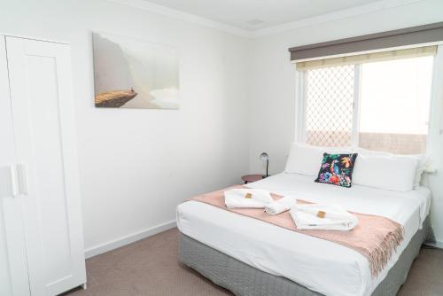 a bedroom with a bed with two towels on it at Apartment 25 Burswood in Perth