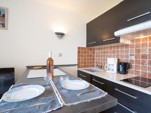 - une cuisine avec 2 assiettes et des verres à vin sur un comptoir dans l'établissement Apartment Les Aigues Marines-58 by Interhome, à Saint-Cyr-sur-Mer