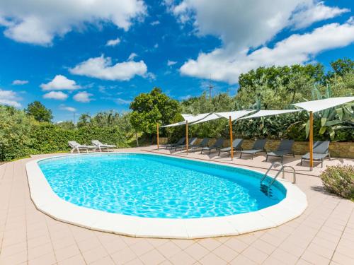 a swimming pool with chairs and umbrellas at Holiday Home Tegliaia by Interhome in Starda