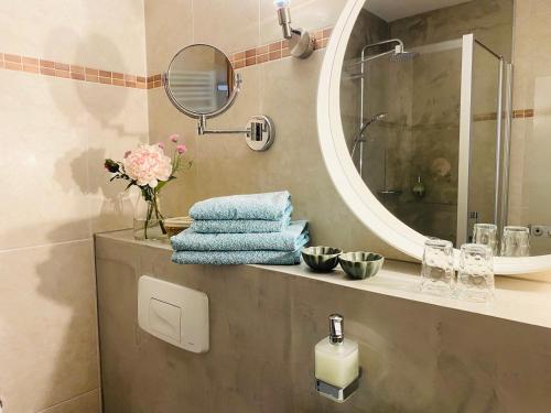 een badkamer met een wastafel, een spiegel en handdoeken bij Pension22 in Meißen