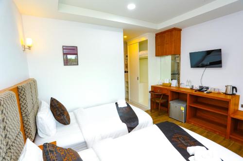 a hotel room with two beds and a desk at My Memory Mueang Loei in Loei