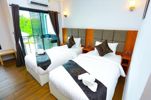 a hotel room with two beds and a window at My Memory Mueang Loei in Loei