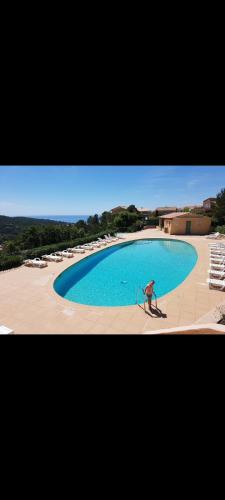 une personne debout en face d'une piscine dans l'établissement Studio 4 pers VUE MER les issambres, à Roquebrune-sur Argens