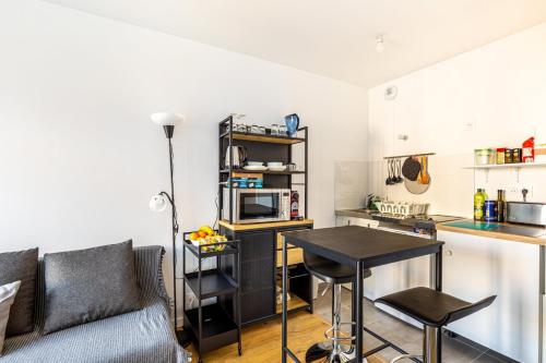 un salon avec un canapé et une table et une cuisine dans l'établissement GuestReady - Nice cosy studio with a balcony, à Nanterre