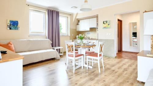 a kitchen and living room with a table and chairs at Apartamenty Sun & Snow Mare Promenada in Międzyzdroje