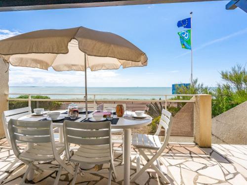 une table et des chaises avec un parasol et l'océan dans l'établissement Holiday Home La Grande Côte bis by Interhome, à Saint-Palais-sur-Mer