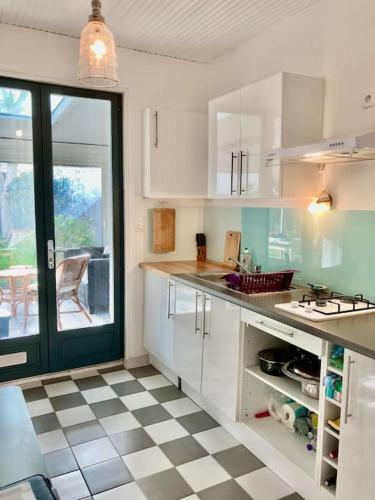 - une cuisine avec des placards blancs et un sol en damier dans l'établissement Maison pêcheur centre Saint Gilles Croix de Vie avec ménage et draps inclus, à Saint-Gilles-Croix-de-Vie