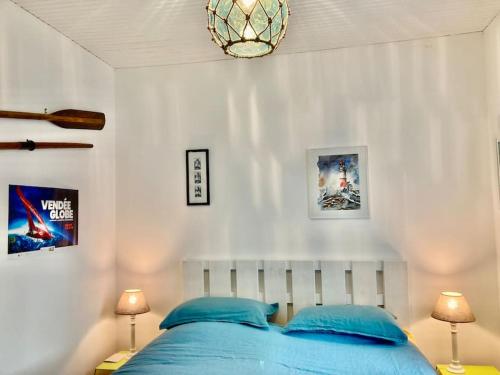 - une chambre avec un lit bleu et deux lampes dans l'établissement Maison pêcheur centre Saint Gilles Croix de Vie avec ménage et draps inclus, à Saint-Gilles-Croix-de-Vie