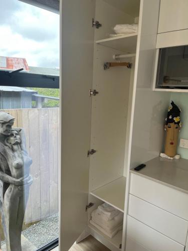 a room with white cabinets and a statue in it at Matakana Central 981 in Matakana
