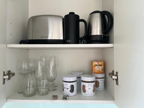 a kitchen shelf with various kitchen items on it at Matakana Central 981 in Matakana