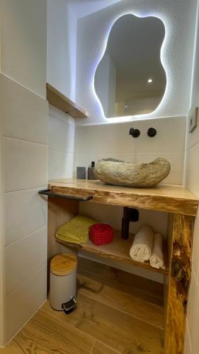 a bathroom with a shelf with a mirror and towels at beb Aria di Montagna in Forcola