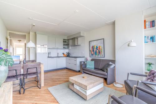 a living room with a table and a kitchen at Appartementencomplex Juliana 146 in De Koog