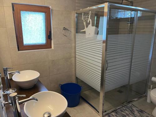 a bathroom with a glass shower and a sink at Cozy Hide Away Frantato in Akamatra