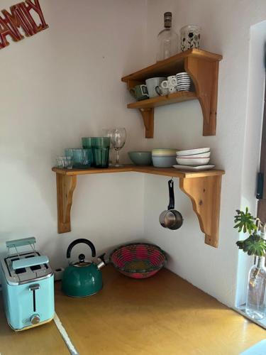 a kitchen with wooden shelves on the wall and a stove at Cozy Hide Away Frantato in Akamatra