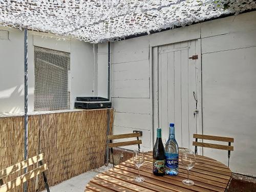 - une table en bois avec 2 bouteilles et des verres dans l'établissement Cabanon de Pêcheur - Vallon des Auffes - Les Frères de la Loc', à Marseille