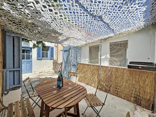 - une terrasse avec une table et une bouteille de vin dans l'établissement Cabanon de Pêcheur - Vallon des Auffes - Les Frères de la Loc', à Marseille
