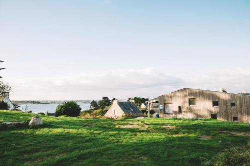 an old barn and a house in a field at Ostal Île de Batz - Auberge de jeunesse in Île de Batz