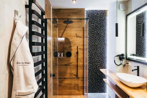 une salle de bain avec douche et lavabo dans l'établissement Apartamenty Bujaś Resort Białka Blue Ski - obok Termy Bania, à Białka Tatrzańska