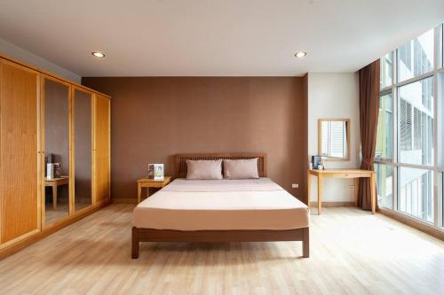 a bedroom with a bed and a large window at 181 Ekkamai Studio Apartment in Bangkok