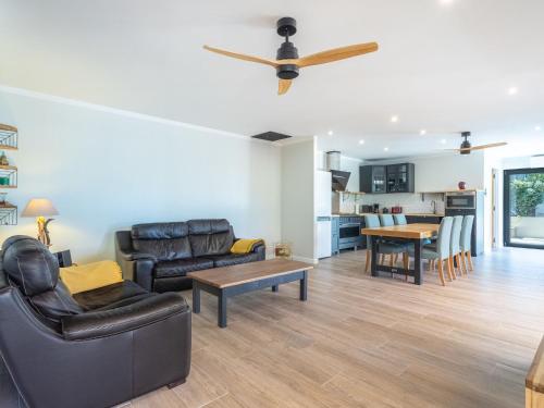 Il comprend un salon doté d'un mobilier en cuir et d'un ventilateur de plafond. dans l'établissement Holiday Home Maison Flocy by Interhome, au Lavandou