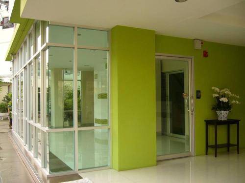a green wall with glass doors in a building at 181 Ekkamai Studio Apartment in Bangkok