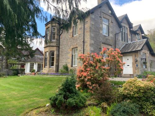 a large stone house with a yard at Lubnaig Guest House in Callander